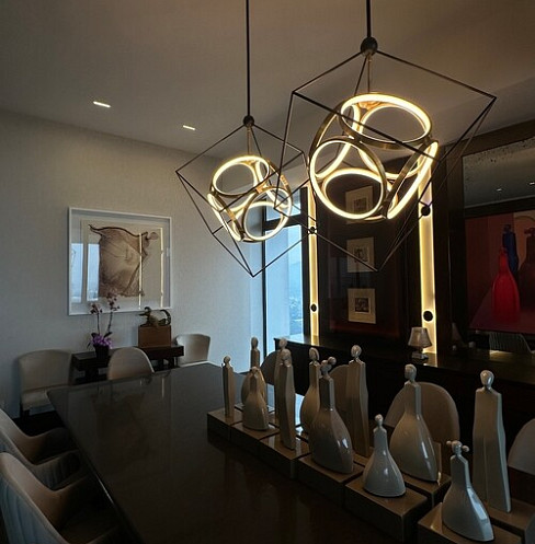 Dining area with sculptural pendant lights designed to complement the art collection