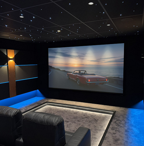 Converted barn cinema with large projection screen, starlight ceiling and blue accent lighting