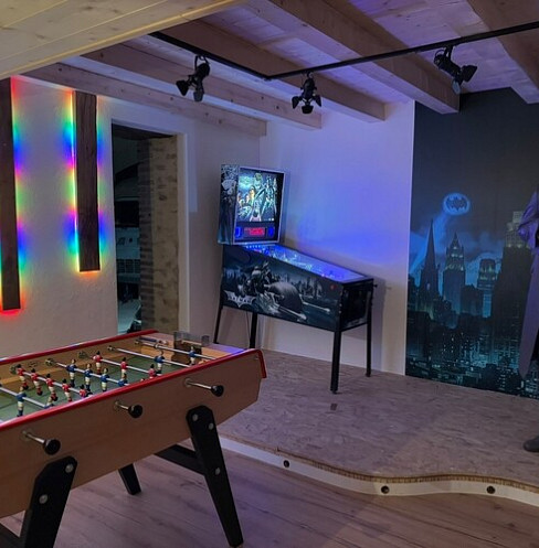 Entertainment lounge with foosball table, pinball machine and color-changing wall lights