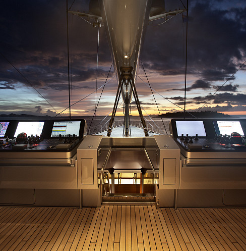 Superyacht helm at sunset with navigation displays and centralized system monitoring