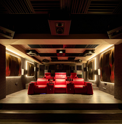 Rear view of tiered red cinema seating and commercial-grade projection system
