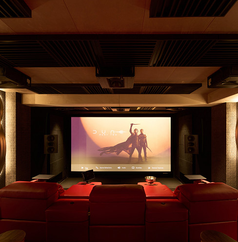 Waveforming home cinema with red recliners, large screen and extensive acoustic treatment