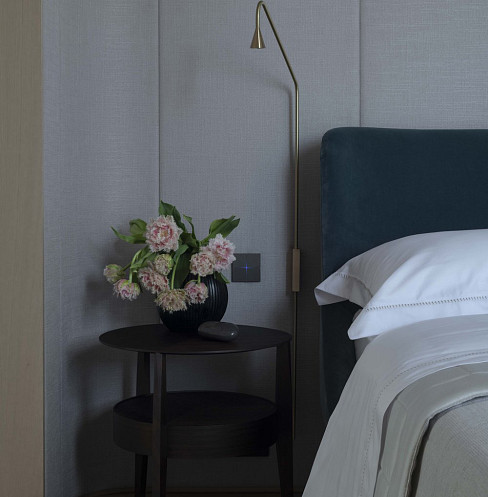 Bedroom with integrated reading light, bedside controls and upholstered acoustic wall