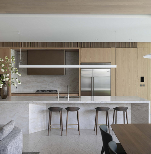 Open-plan kitchen with marble island, pendant light and integrated smart controls