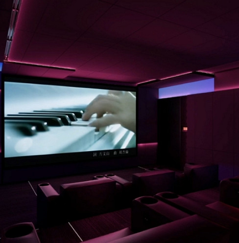 Multifunctional media room with large screen and color-changing purple accent lighting