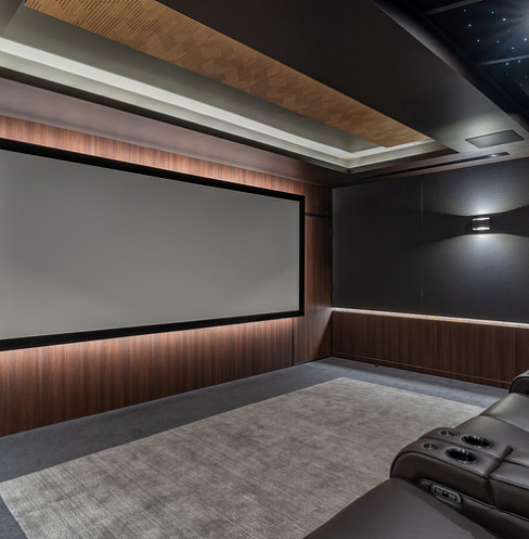 Wide projection screen framed by timber acoustic panels and concealed lighting