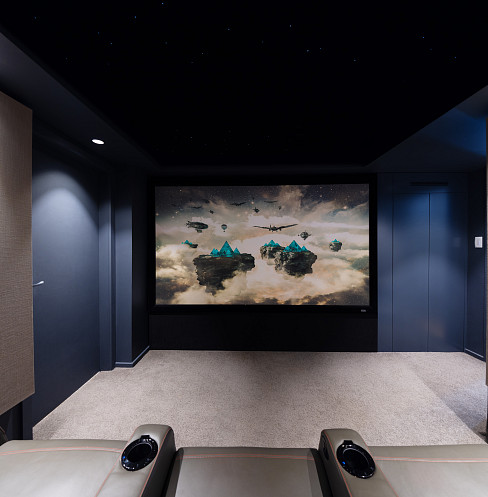 Vista de la pantalla grande desde los asientos traseros de un cine en casa familiar y compacto