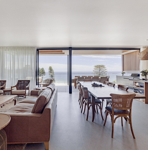 Salón-comedor diáfano de estilo costero, con sistema de audio en toda la vivienda y ventanas automatizadas
