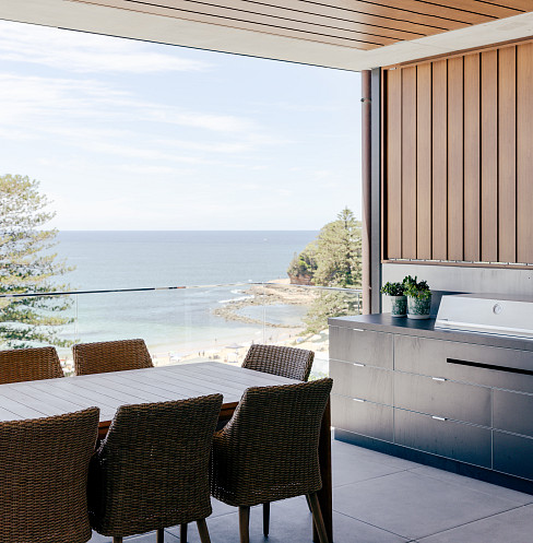 Cocina exterior y zona de comedor con vistas al mar e iluminación inteligente integrada