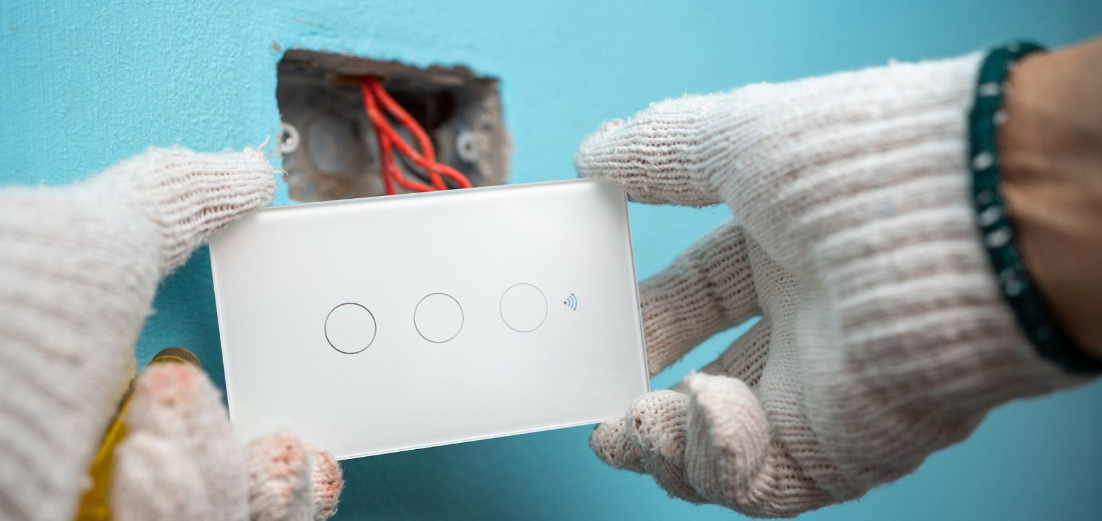 Un profesional especializado en domótica instala un interruptor de luz inteligente