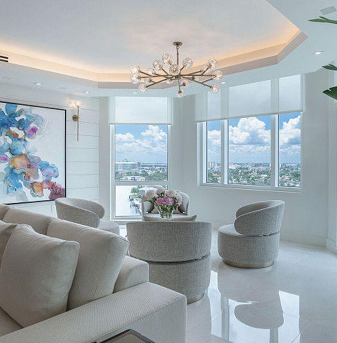 Sala de estar con diseño curvo, altavoces ocultos, iluminación inteligente y vistas panorámicas al mar