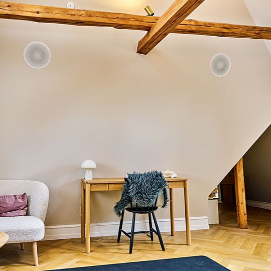 Home office with two discreet in-ceiling DALI speakers above a wooden desk
