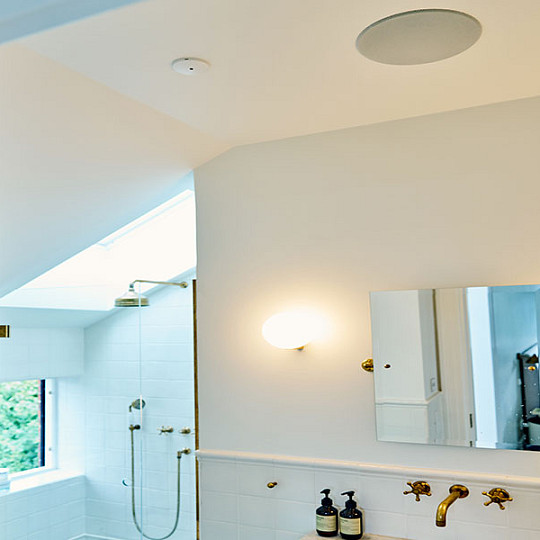Bathroom with a moisture-resistant DALI in-ceiling speaker above the shower area
