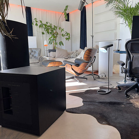Subwoofer DALI SUB V-16 F negro integrado en una sala de audición contemporánea