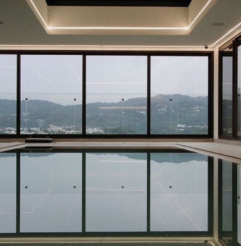 Indoor swimming pool with automated lighting and panoramic city views