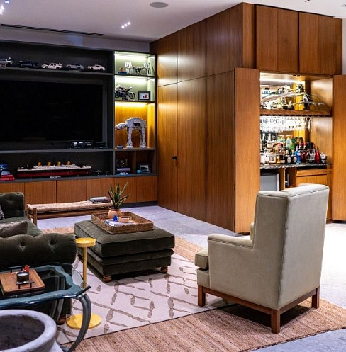Sala de ocio en casa con televisión integrada, sistema de audio y controles inteligentes ocultos