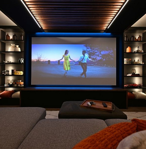 Deep sectional seating beneath acoustic treatment in a comfortable family media room