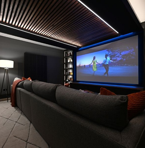 Multifunctional media room with large screen, timber ceiling and integrated lighting