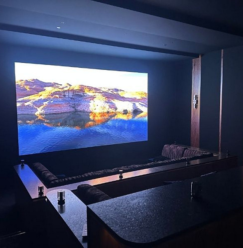 Sala de cine en casa de lujo diseñada en torno a una luminosa pared de vídeo LED de visión directa