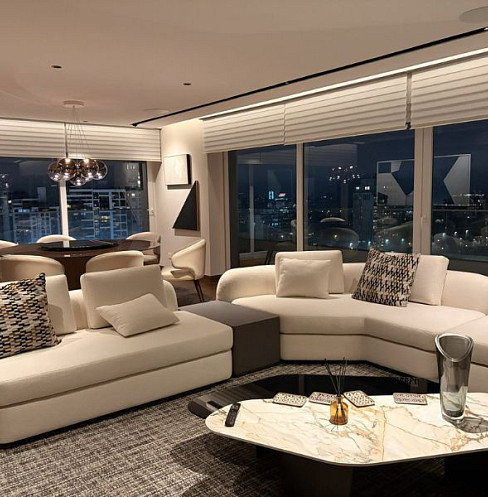 Open-plan apartment lounge with multi-zone audio and panoramic city views