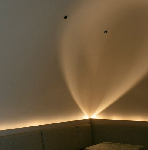 Curved lounge wall with discreet flush-mounted commercial speakers