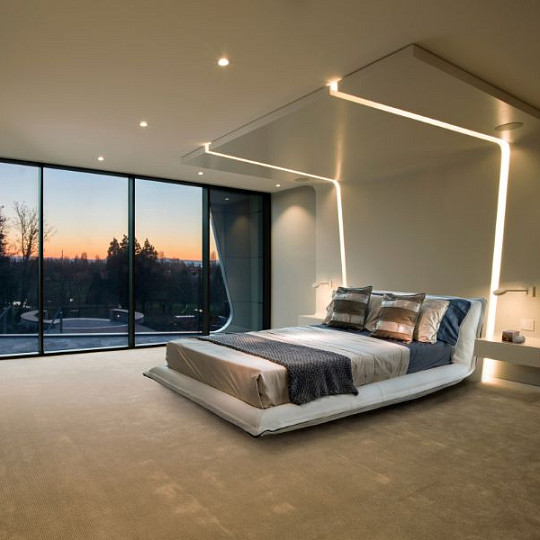 Habitación moderna con iluminación ambiental cálida integrada al atardecer