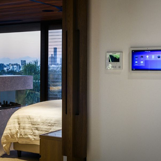 Habitación inteligente con controles táctiles montados en la pared para la iluminación y la automatización