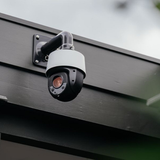 Outdoor smart security camera mounted beneath a roof eave