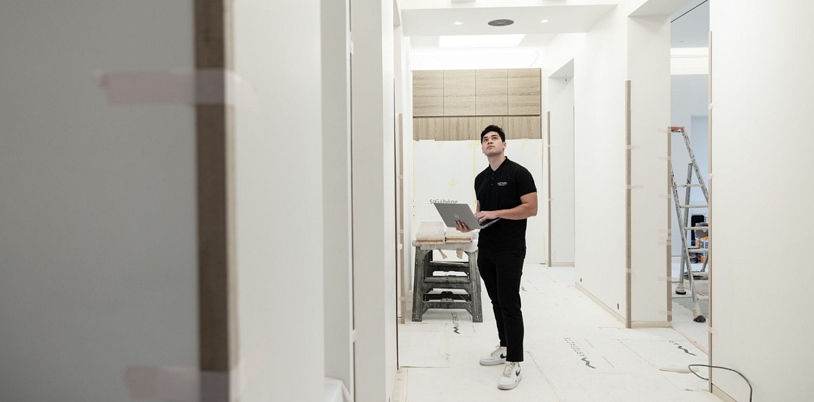 Smart home installer holding a tablet in a home under construction
